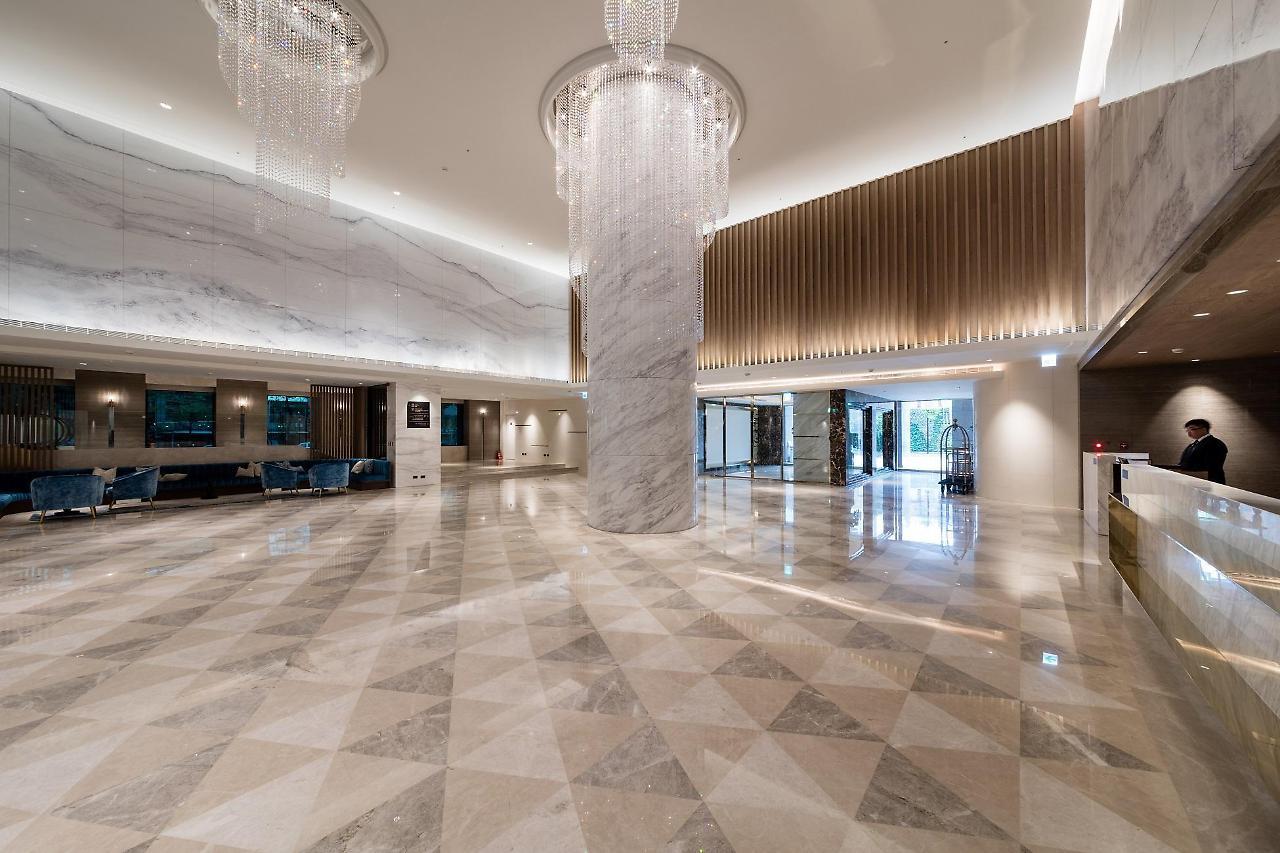 臺北 台北凯达大饭店酒店 外观 照片 The photo shows a spacious and elegant hotel lobby. The floor is covered with large, polished tiles arranged in a diamond pattern, creating a sophisticated look. There are tall marble columns and stylish chandeliers hanging from the ceiling, adding t