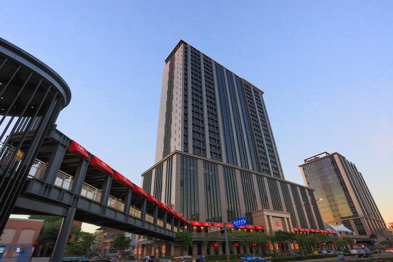 臺北 台北凯达大饭店酒店 外观 照片 The photo depicts a modern high-rise building with a sleek design, featuring multiple floors and large windows. The structure is set against a clear sky, suggesting it is either early morning or late afternoon. In the foreground, there is a pedestria